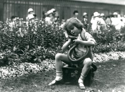 Una niña, Betty, sosteniendo una serpiente índigo oriental, sentada en un baúl de cuero, Zoológico de Londres, 1924 de Frederick William Bond