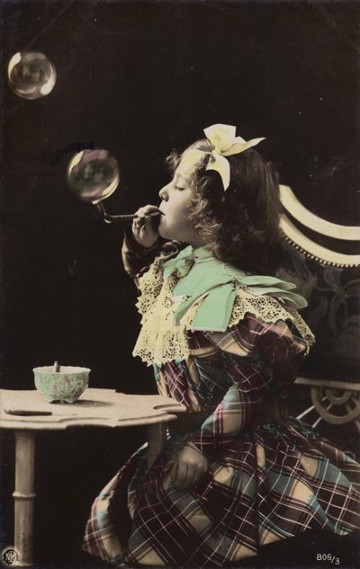 Una niña soplando burbujas de una pipa de French Photographer