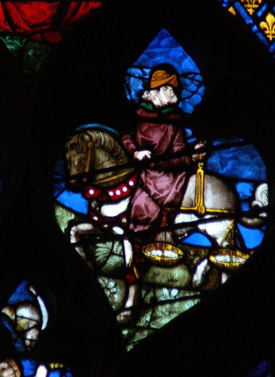 La ventana rosa oeste representando una escena del Libro de Apocalipsis: Un jinete (su caballo no es negro como en el texto) llevando las balanzas para medir el trigo y la cebada (6:5) de French School