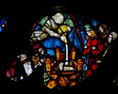 La ventana rosa oeste que representa una escena del Libro de Apocalipsis: la quinta copa es derramada sobre el trono de la bestia - un sillón Dagobert, sus súbditos mordiéndose la lengua de dolor (16:10) de French School