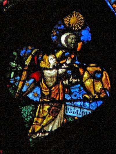 La ventana rosa oeste que representa una escena del Libro de Apocalipsis: cuarta trompeta, sol, luna y estrellas oscureciéndose, y el águila como el ángel gritando Ay, Ay, escrito debajo (8:12-13) de French School