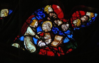 La ventana rosa oeste que representa una escena del Libro de Apocalipsis: cabezas de los siete truenos (en una nube azul) y San Juan siendo prohibido de escribir (10:3-5) de French School