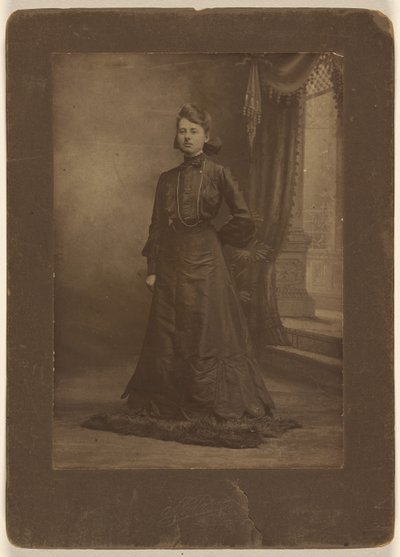[Retrato de una mujer joven con vestido negro largo, de pie] de George W. Killian