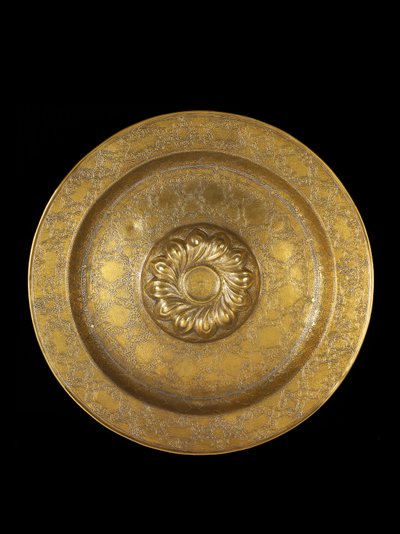 Plato de latón grabado con incrustaciones de plata, el medallón central rodeado por gajos en espiral repujados, 1500-1525 de German School