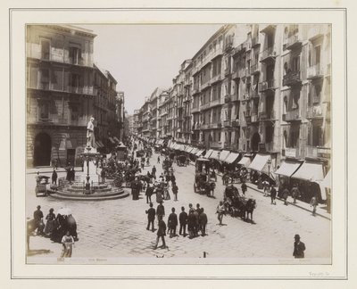 Vista de la Via Roma en Nápoles, con una estatua, tiendas, carruajes tirados por caballos y transeúntes de Giorgio Sommer