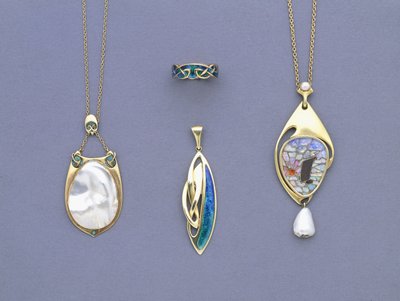 Un grupo de colgantes y un anillo de metal amarillo y esmalte de Liberty & Co diseñados por Archibald Knox de Giovanni Bigatti
