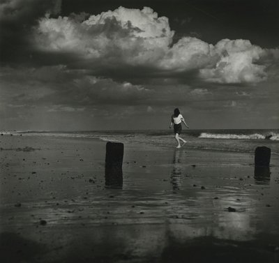 Niño jugando con las olas en la playa. de Godfrey Macdominic