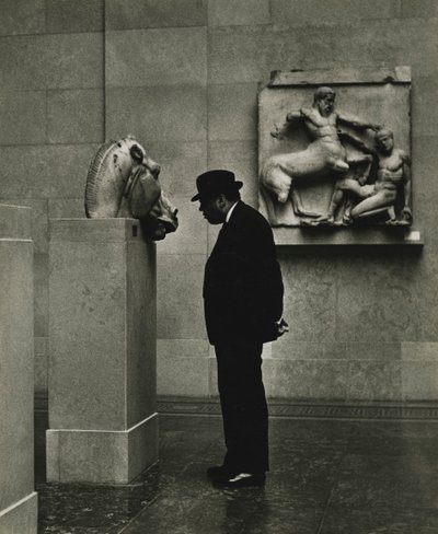 Hombre mirando esculturas en el Museo Británico, Londres, años 50. de Godfrey Macdominic