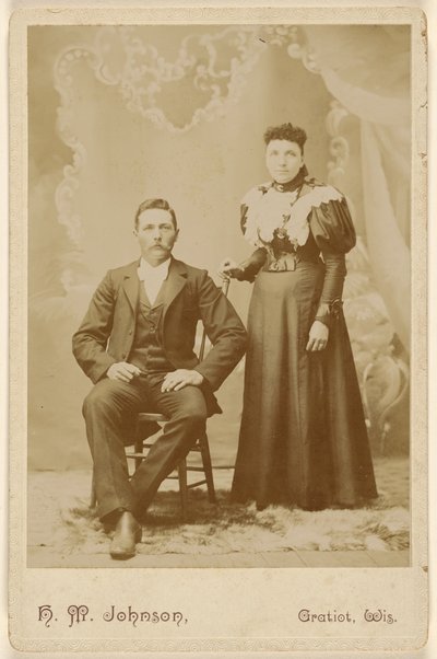 [Pareja no identificada: hombre con bigote sentado, mujer de pie] de H. M. Johnson