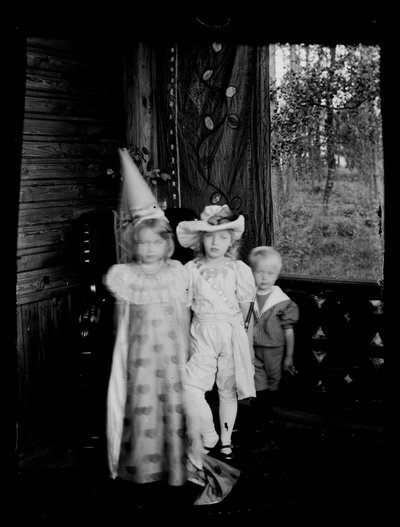 Niños disfrazados en el porche del chalet de los Andersin, los niños Gadd y Karin y Lisa Anders. de Hugo Simberg