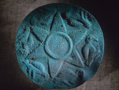 Estrella de cobre, desenterrada al sur de la escuela, adornaba un escudo de guerrero hecho de cañas y juncos. Se encontró junto al Sr. Tupac. de Ira Block
