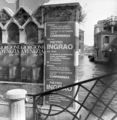 Vista de un canal en Venecia con carteles que anuncian una exposición de Giorgione y un manifiesto político en primer plano de Italian Photographer
