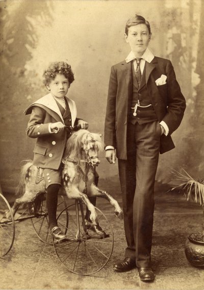 Niño montado en su caballo como un triciclo, su hermano mayor al lado, 1880s de J. H. Killick