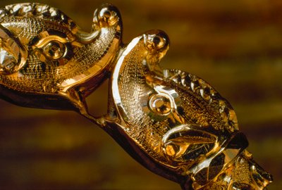 Una pulsera de oro hecha a mano con dos cabezas de tiburón chocando. América del Sur. de James L Stanfield