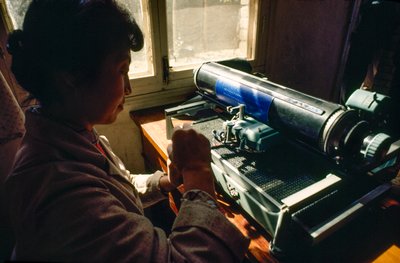 En la oficina de la comuna, un miembro teclea en una máquina de escribir china. Comuna de Chun Xing, Y... de James L Stanfield