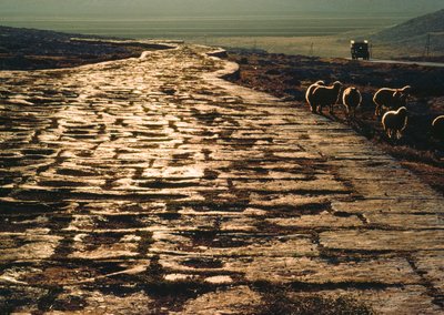 Carretera moderna de macadán paralela a la antigua calzada romana de piedra caliza. Cerca de Alepo, Siria. de James L Stanfield