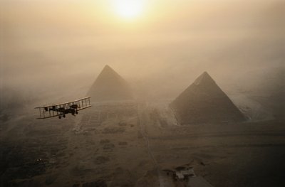 El avión de época Vimy sobrevuela las pirámides envueltas en niebla durante un sol dorado... de James L Stanfield