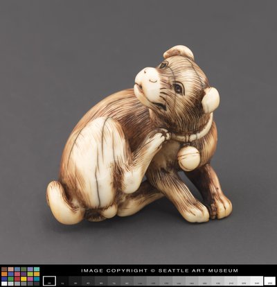 Netsuke modelado como un perro rascándose el cuello de Japanese School
