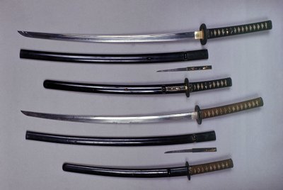 Arriba: una katana, espada japonesa y su funda, wakizashi, espada corta japonesa en su funda, pequeño daga Kokatawa guardada en la misma vaina. Las tres son del siglo XVIII. Las inferiores son del siglo XVII. de Japanese School