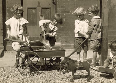 Niños pequeños cargando grava en un carro, c.1915 de Jessie Tarbox Beals