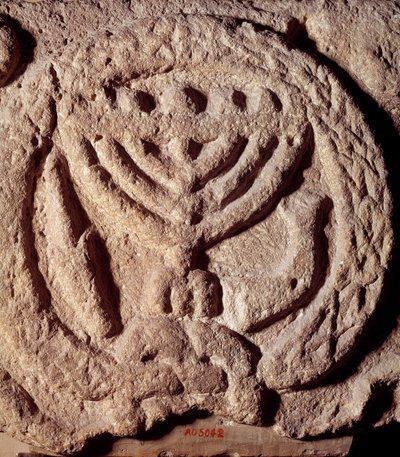 Judaísmo: elemento arquitectónico en basalto de una sinagoga decorado con un candelabro de siete brazos (Menorá o Menorah), palma y trompeta. De Transjordania. Alrededor del año 100 d.C. París, Museo del Louvre de Jewish School