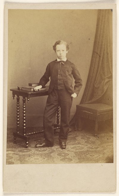 [Niño no identificado en traje de pie en una mesa con libros en la parte superior] de Joseph Brown