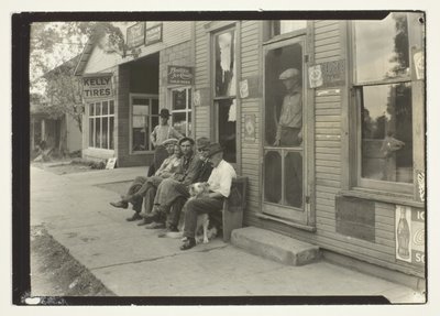Hombres con perro sentados en un banco frente a un almacén de Lewis Wickes Hine