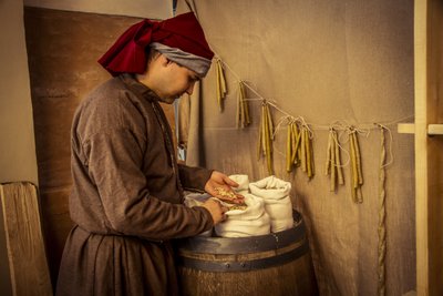 Recreación histórica: Velas y sacos de trigo, centeno y cebada en la botica de Diotaiuti, Imola, Italia, mediados del siglo XIV de Unbekannt Unbekannt