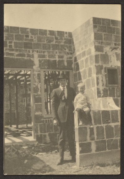 [Hombre de pie con niño en casa en construcción] de Louis Fleckenstein