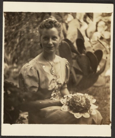 [Mujer con ramo de flores sentada ante un cactus] de Louis Fleckenstein