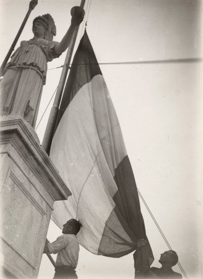 Bandera italiana izada junto a una estatua de Luigi Leoni