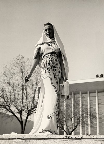Modelo con vestido de noche de tela estampada floral, creado por la casa de alta costura "Lamma". El artículo se completa con un largo velo. de Luis Bogino