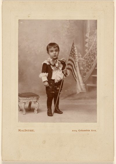 [Niño de pie, sosteniendo una bandera americana] de MacIntire