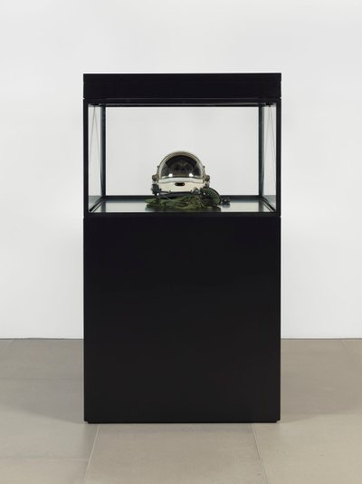 Alpha Omega, 2016 (cristal, pantalla LCD, reproductor multimedia, réplica de una calavera, casco espacial, madera) de Mat Collishaw