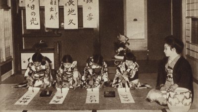 Escolares japonesas escribiendo con pinceles en una clase de jardín de infantes de Photographer Japanese
