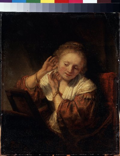Mujer joven probándose pendientes. Mujer joven probándose pendientes. Pintura de Harmenszoon van Rijn conocida como Rembrandt (1606-1669) de Rembrandt Harmensz. van Rijn