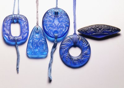 Cuatro colgantes de vidrio turquesa y un broche de vidrio montado en metal dorado de Rene Jules Lalique
