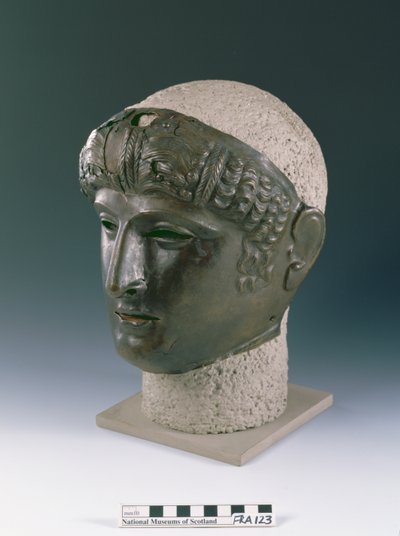 Máscara de desfile de un rostro joven masculino, del sitio romano en Newstead, Melrose, finales del siglo I d.C. (bronce) de Roman