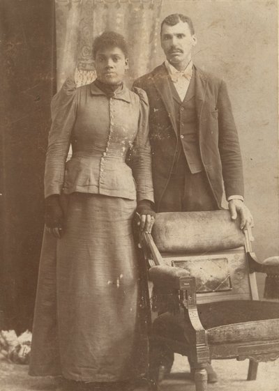 Fotografía de una pareja afroamericana de pie detrás de una silla, ca. 1890 de Schmitz Studio