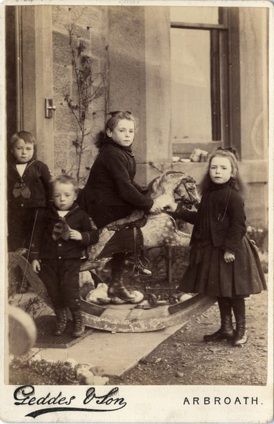 Grupo de niños pequeños y su caballo de juguete de Scottish Photographer