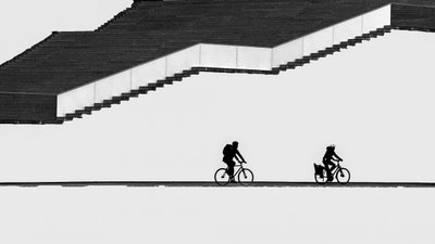 Ciclistas en silueta en las escaleras de Shanrui Ren