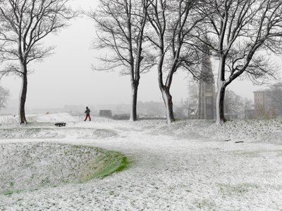 Figura solitaria caminando por la Fortaleza de Copenhague durante una tormenta de nieve, Dinamarca, 2022 (foto) de Sisse Brimberg