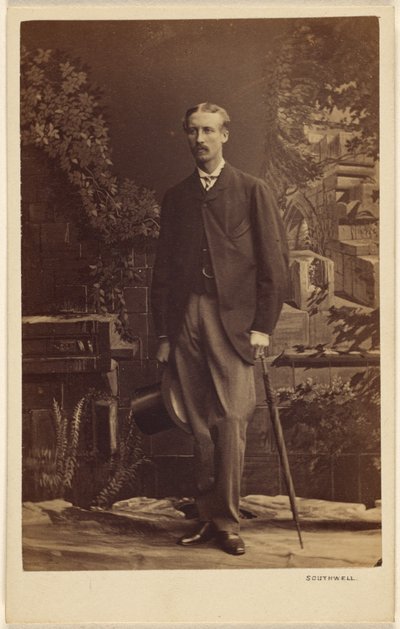 [Hombre no identificado con bigote, sosteniendo un sombrero de copa y un paraguas, de pie] de Southwell Brothers