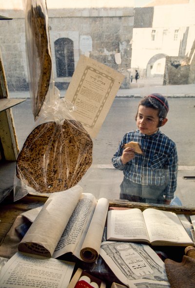 Niño judío conservador comiendo tarta se asoma a una librería religiosa. de Ted Spiegel