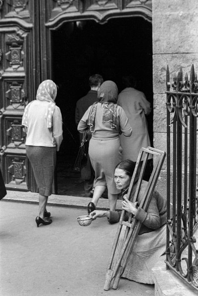 Una mujer lisiada pide limosna mientras los peregrinos entran en el Santuario de Monserrate, Bogotá, Colombia. de Ted Spiegel