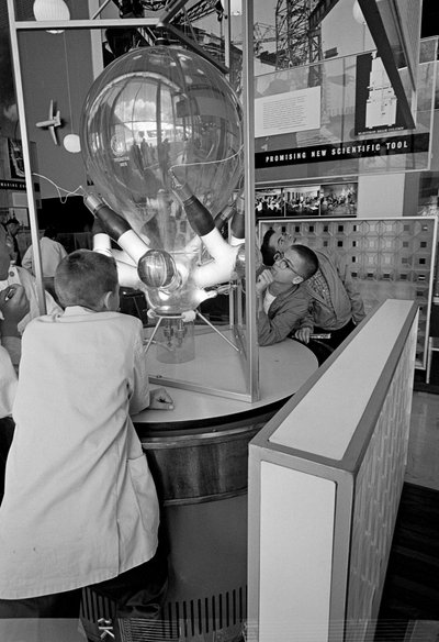 Visitantes de la Feria Mundial de Seattle de 1962 admiran una exposición científica. de Ted Spiegel