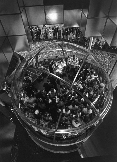 Visitantes de la Feria Mundial de Seattle en el interior de un ascensor abovedado en una exposición de Ted Spiegel