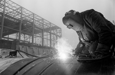 Un soldador utiliza un soplete de acetileno para soldar tuberías industriales en las obras de Hanfor... de Ted Spiegel