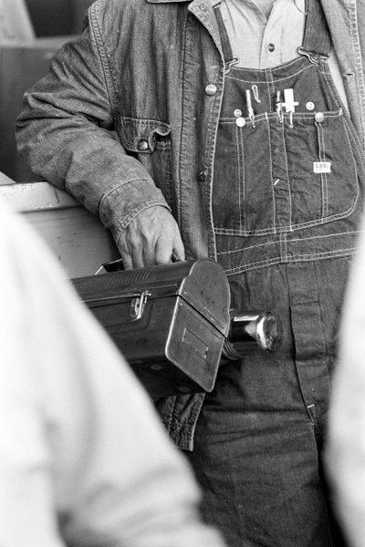 Trabajador con peto sosteniendo una fiambrera. Procesamiento de cobre electrolítico en la... de Ted Spiegel