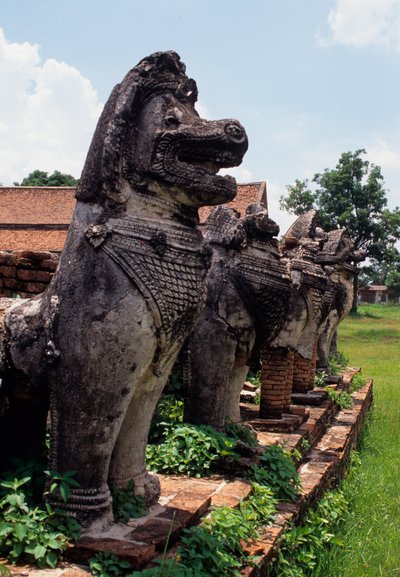 Figuras guardianas de piedra con forma de león construidas alrededor de la base de la estupa de Thai School